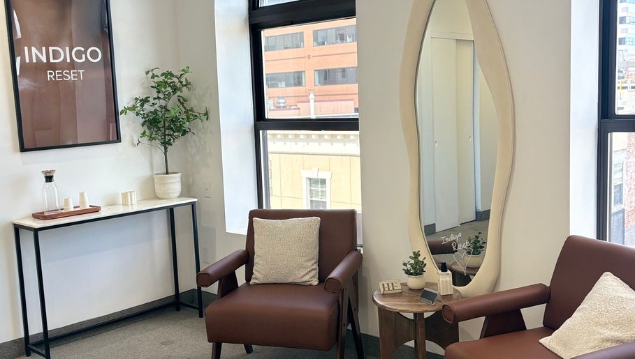 Relaxing lounge area at Bymilauryss, New Brunswick, New Jersey, US, featuring a leather chair and modern decor.