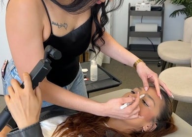 Makeup artist at Bymilauryss in New Brunswick, New Jersey, US, precisely applying eye makeup on a client.