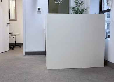 Reception area at Bymilauryss, New Brunswick, New Jersey, US, featuring minimalist decor and greenery.