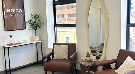 Cozy lounge area at Bymilauryss, New Brunswick, New Jersey, US with brown chairs and a decorative mirror.