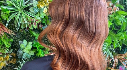 Elegant auburn waves styled at Hair by Elisa Salvatore in Kettering, England, GB, against a lush backdrop.