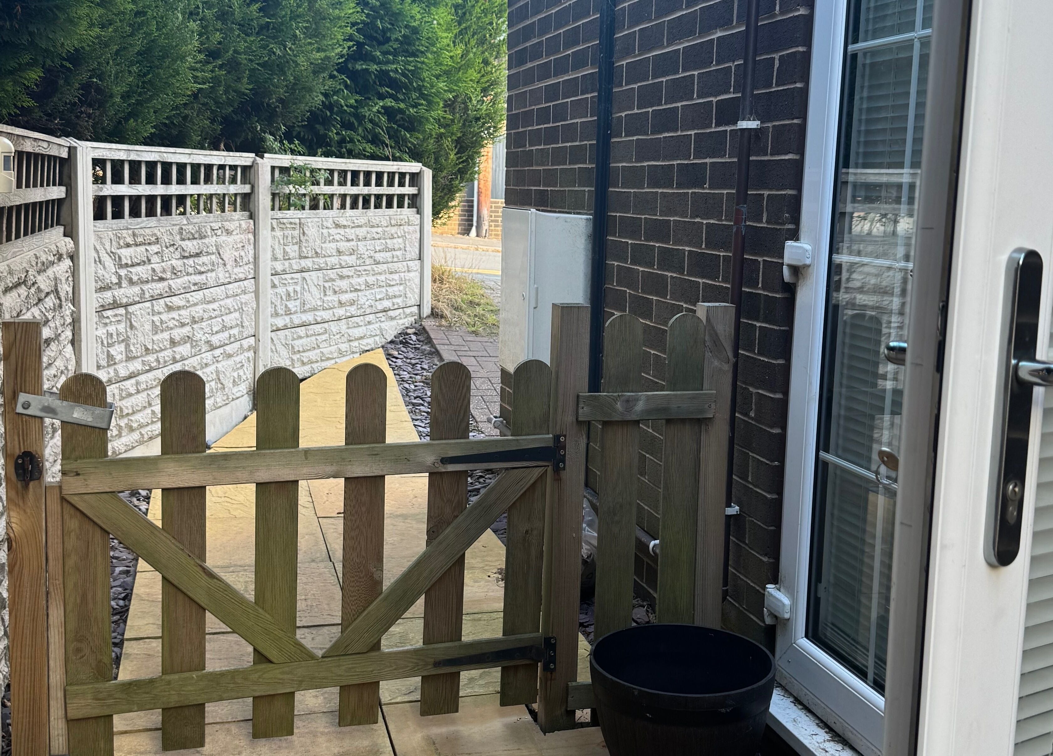 A quaint wooden gate leading to Drew's serene pathway in Stoke-on-Trent, England, GB.