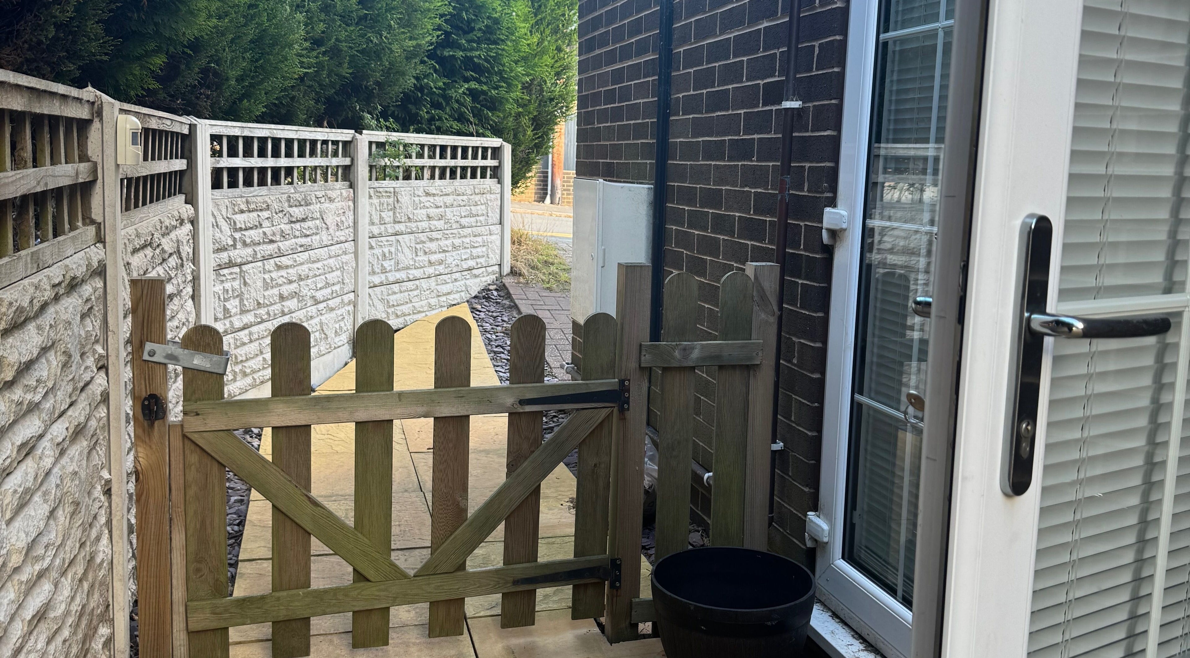 A quaint wooden gate leading to Drew's serene pathway in Stoke-on-Trent, England, GB.