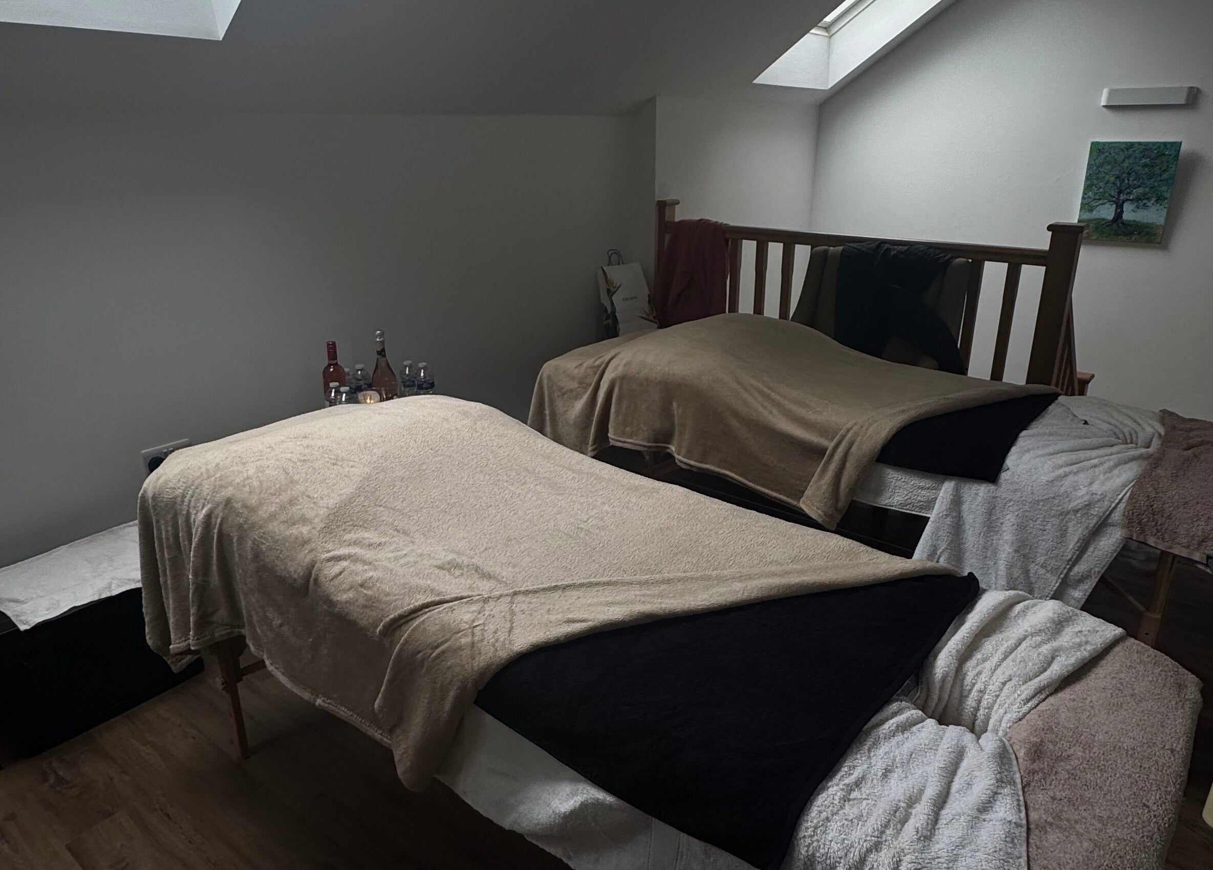 Cozy massage room at Drew in Stoke-on-Trent, England with two massage beds and soft lighting.