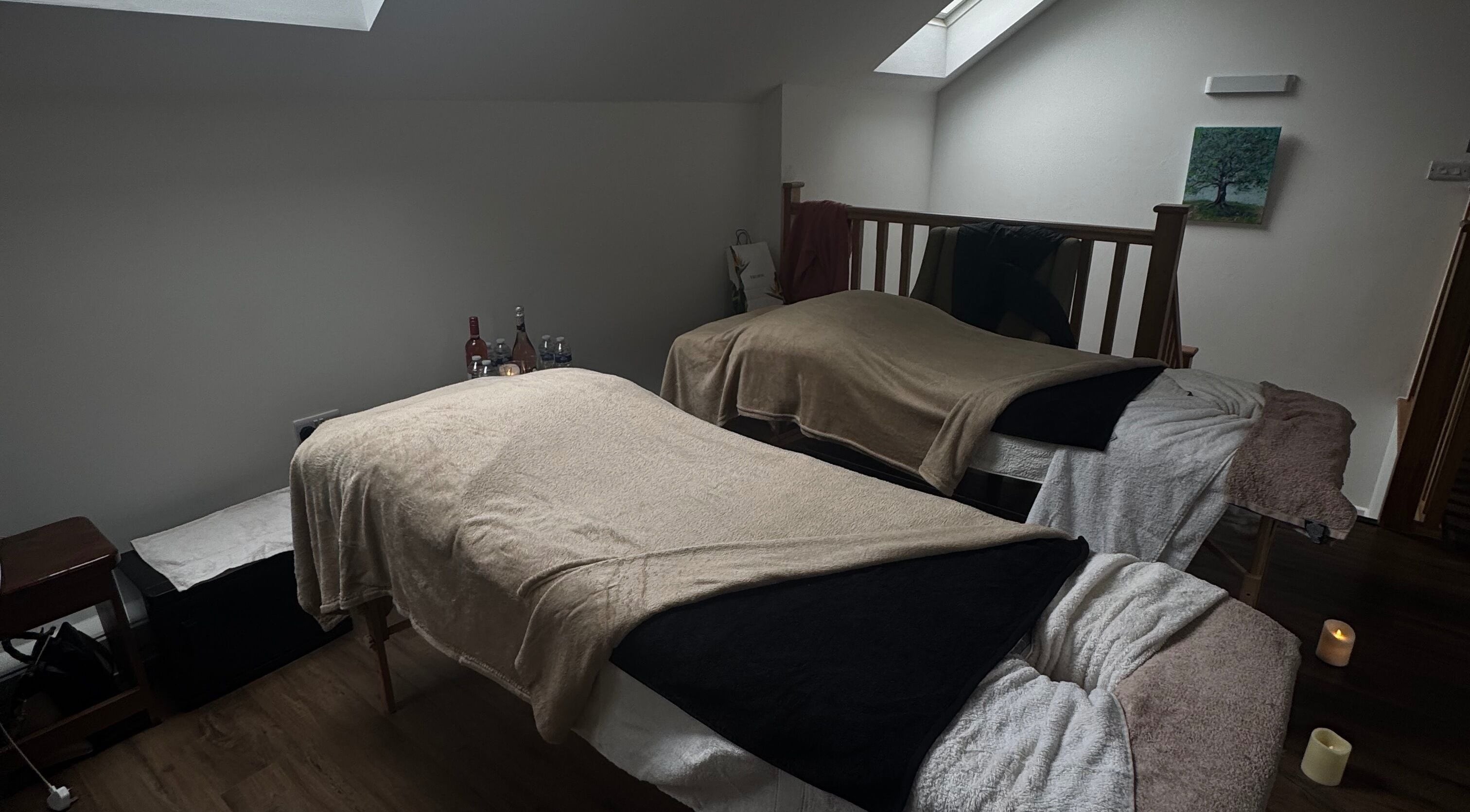 Cozy massage room at Drew in Stoke-on-Trent, England with two massage beds and soft lighting.