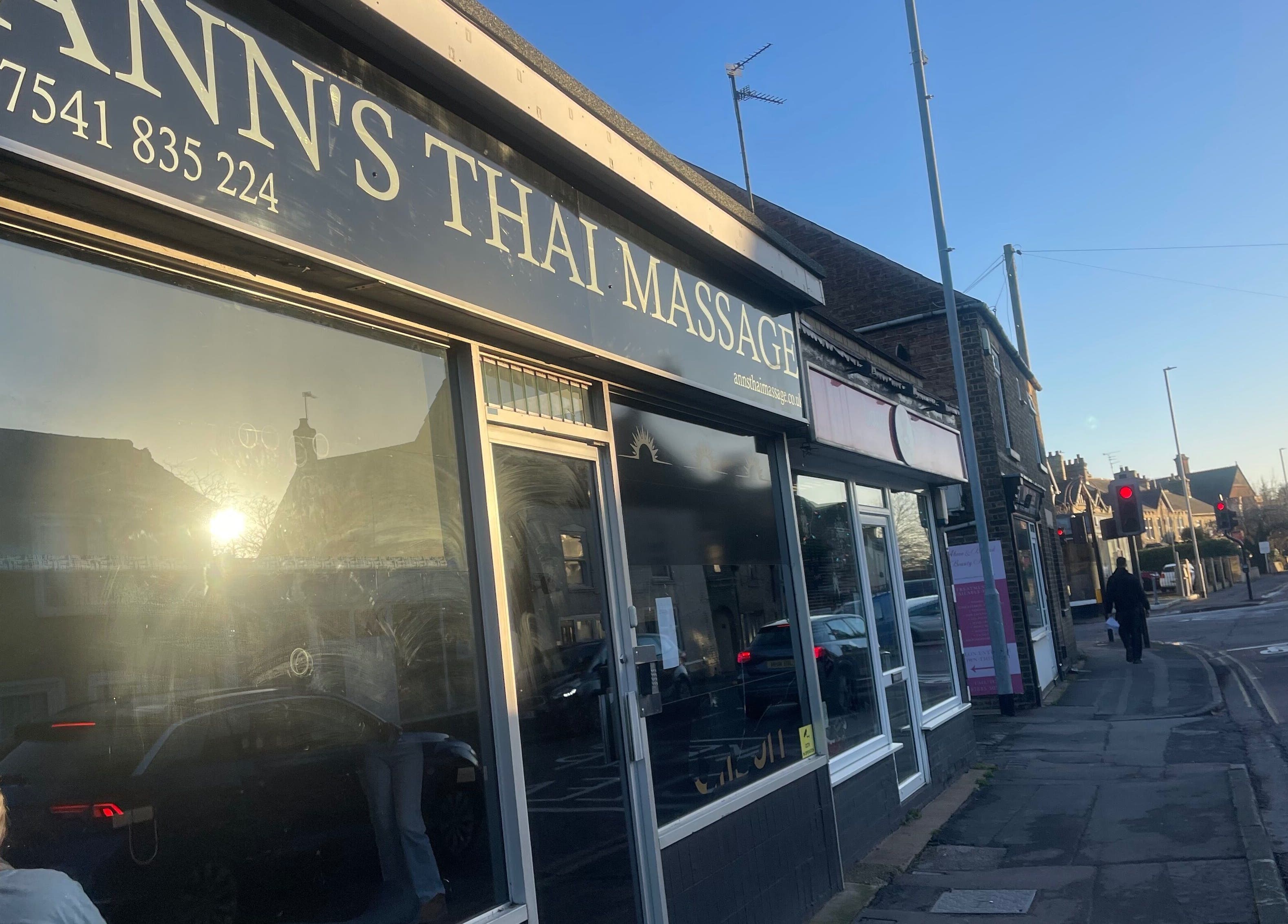 Street view of Ann’s Thai Massage entrance in March, England, GB with morning sunlight reflection.