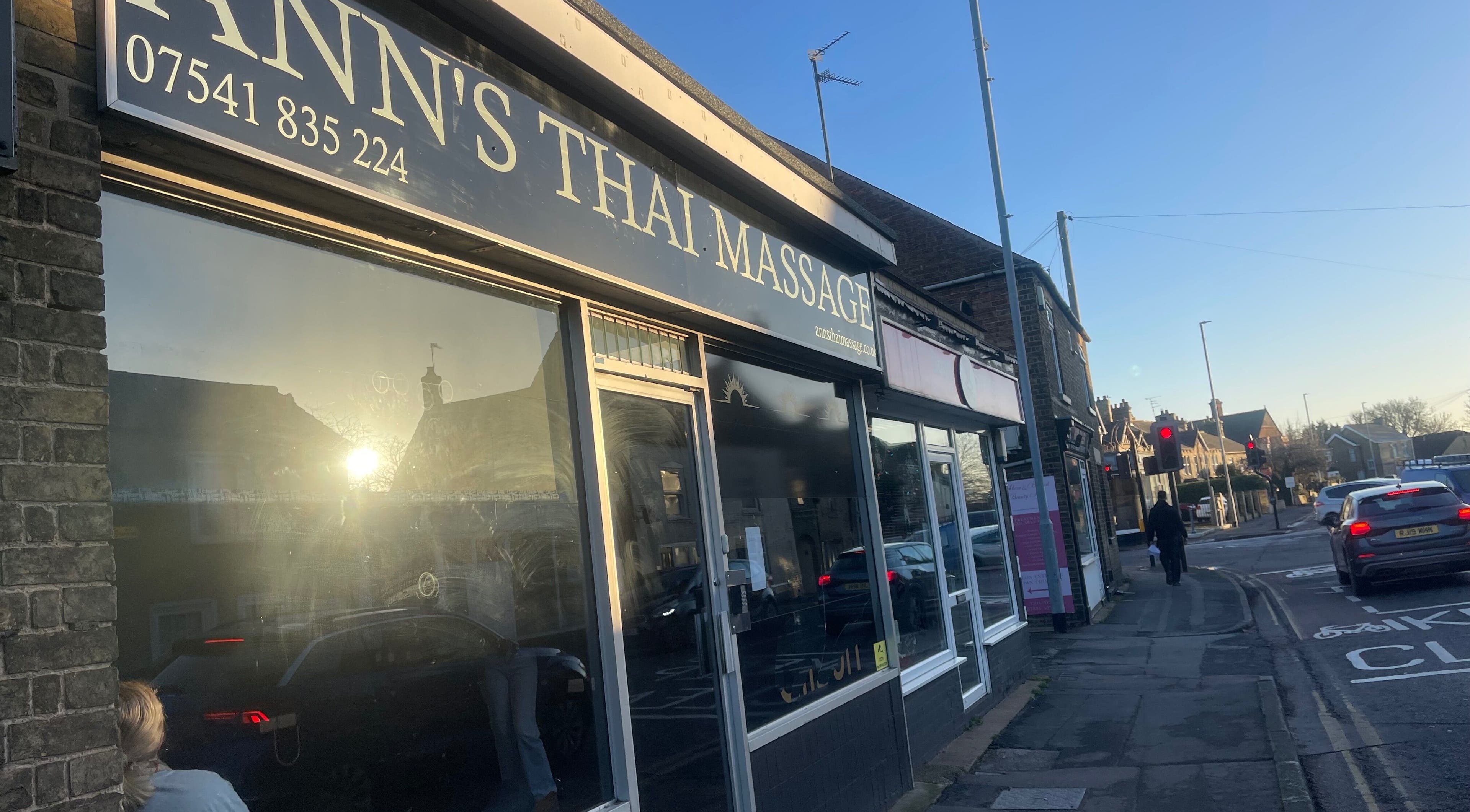 Street view of Ann’s Thai Massage entrance in March, England, GB with morning sunlight reflection.
