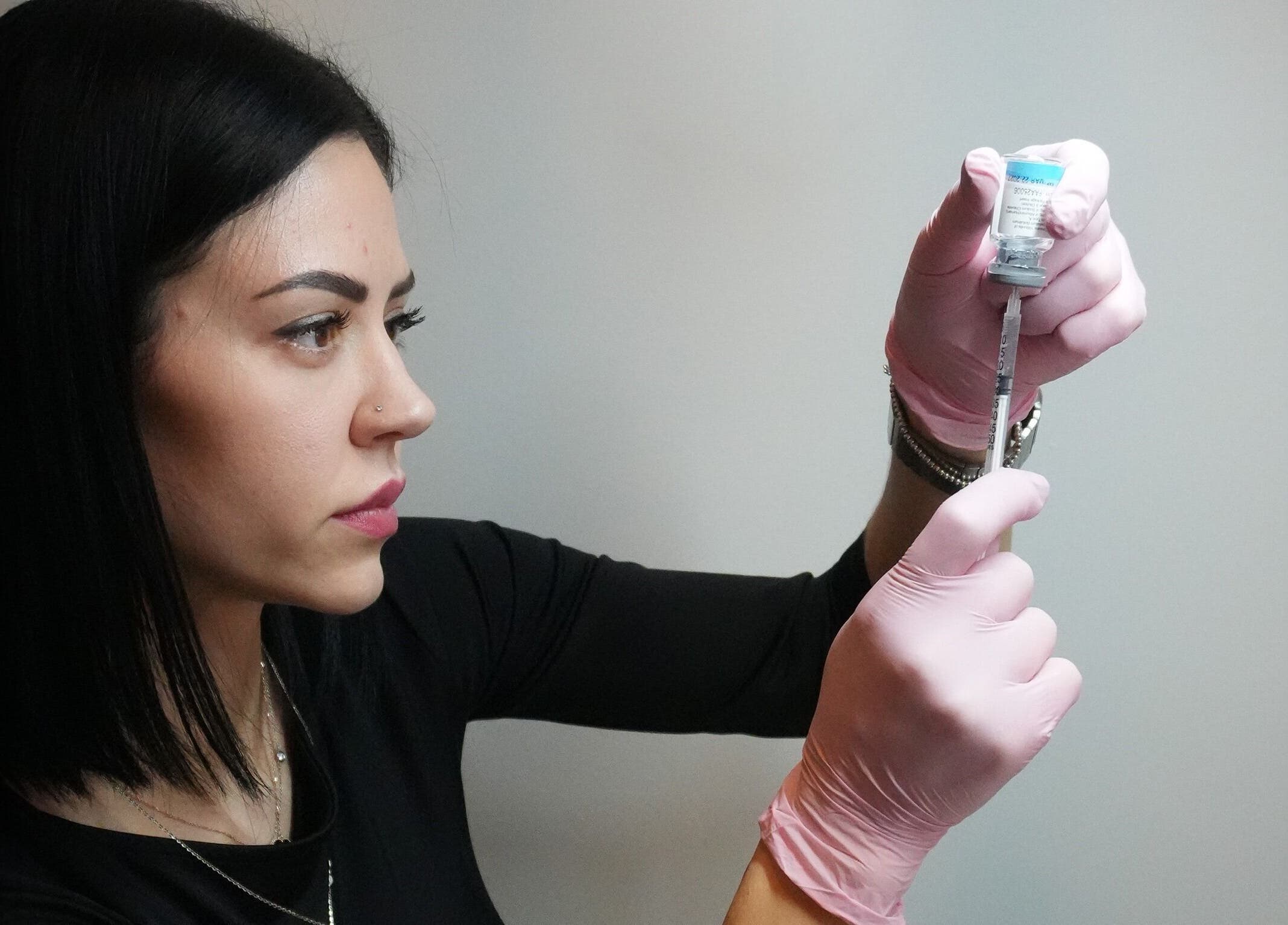 Skilled professional at Nivelle Aesthetics in Schaumburg, Illinois, US preparing syringe for aesthetic treatment.