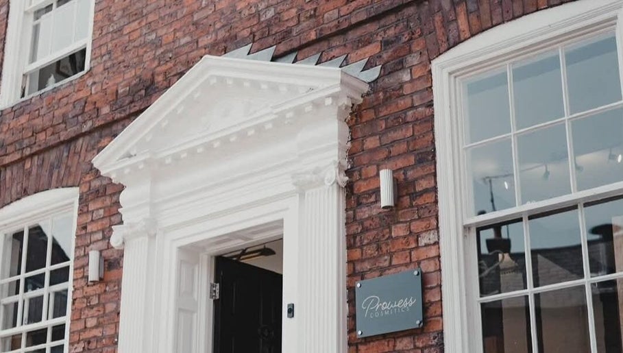 Charming brick facade of Charlotte Elizabeth Tattoos, Chester, England, GB with white detailed entryway.