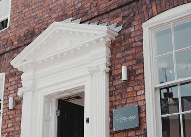 Charming brick facade of Charlotte Elizabeth Tattoos, Chester, England, GB with white detailed entryway.