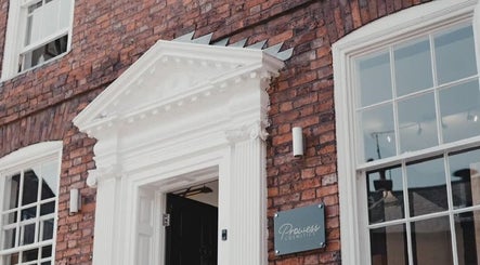 Charming brick facade of Charlotte Elizabeth Tattoos, Chester, England, GB with white detailed entryway.