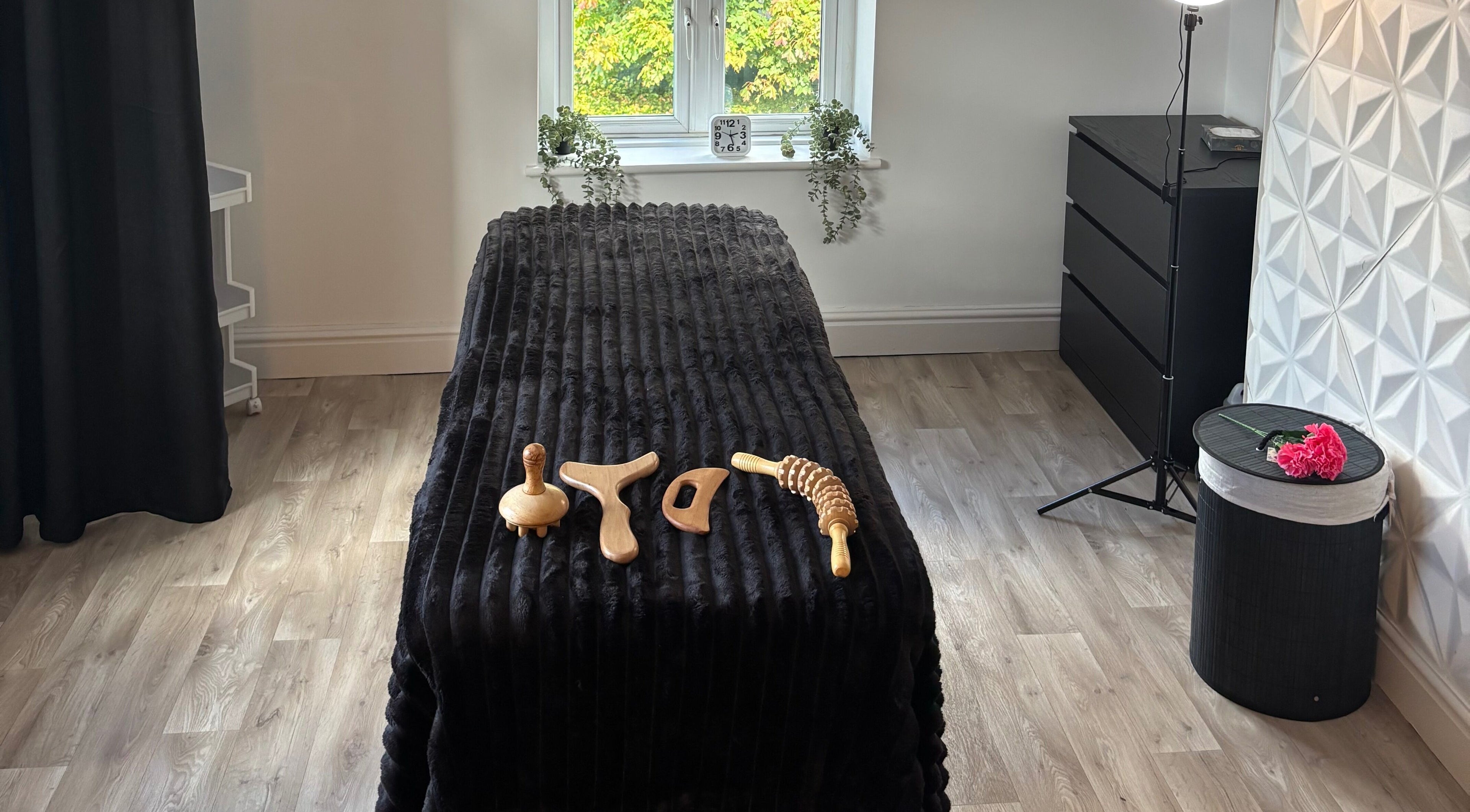 Massage table with wooden tools at True Reflection, Cheshire, England, GB, highlighting a peaceful spa environment.
