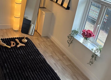 Cozy treatment room at True Reflection, Cheshire, England, GB, featuring massage tools and ambient lighting.