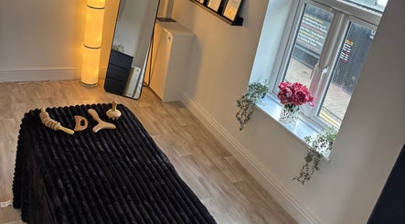 Cozy treatment room at True Reflection, Cheshire, England, GB, featuring massage tools and ambient lighting.