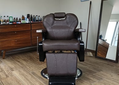 Silla de cuero marrón en Home Harmony, Ciudad De México, MX, con espejo y productos de belleza.