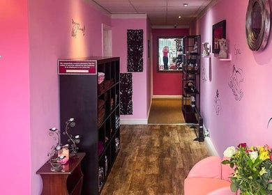 Relaxing interior of Bua Siri Thai Massage in Bournemouth, England with pink walls and calming floral decor.