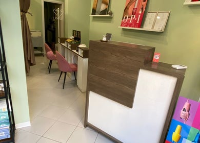 Accogliente reception di Yantra Luxury a Torino, Piemonte, IT con poltrone rosa e prodotti espositi.