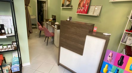 Accogliente reception di Yantra Luxury a Torino, Piemonte, IT con poltrone rosa e prodotti espositi.