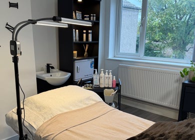 Relaxing treatment room at Unforgotten Skin, Winterbourne, England, GB, with calming decor and natural light.