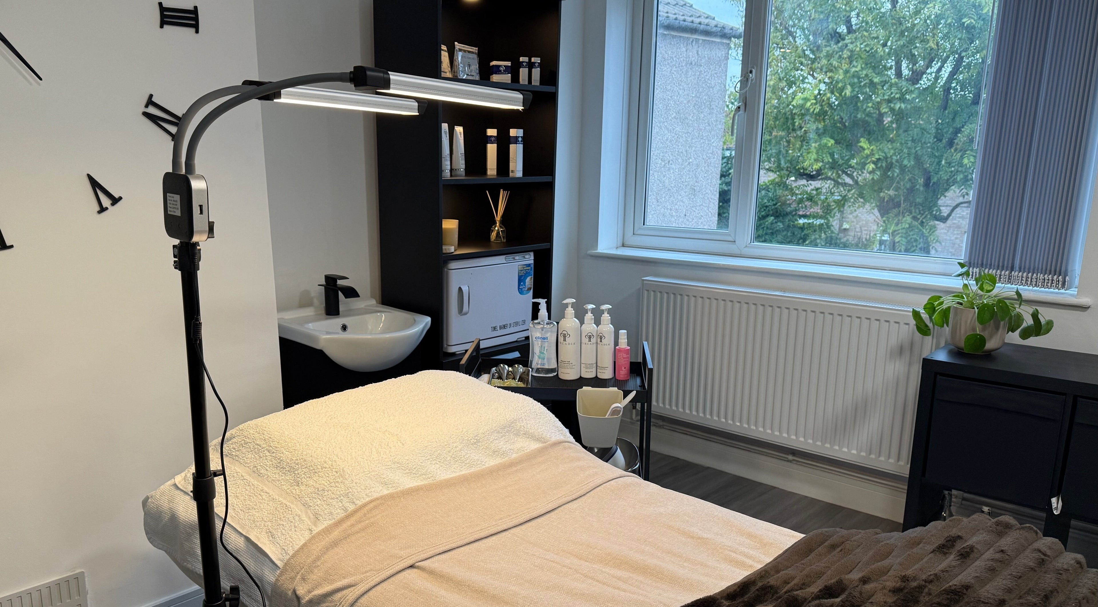 Relaxing treatment room at Unforgotten Skin, Winterbourne, England, GB, with calming decor and natural light.
