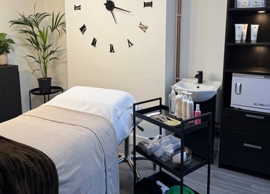 Cozy treatment room at Unforgotten Skin, Winterbourne, England, GB, featuring a plush massage bed and calming decor.