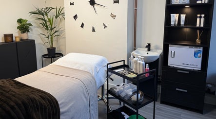 Cozy treatment room at Unforgotten Skin, Winterbourne, England, GB, featuring a plush massage bed and calming decor.