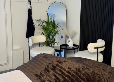 Cozy treatment room at Unforgotten Skin in Winterbourne, England, GB with plush chairs and modern decor.