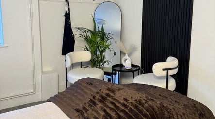 Cozy treatment room at Unforgotten Skin in Winterbourne, England, GB with plush chairs and modern decor.