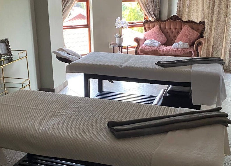 Luxurious treatment room at Rifumo Boutique Spa, Mbombela, Mpumalanga, ZA, featuring elegant decor and massage tables.