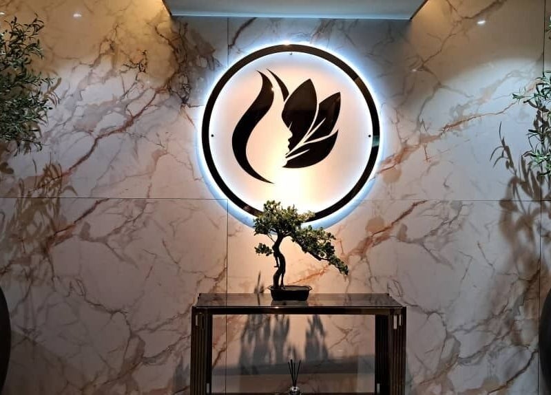 Elegant entry at Lindo Clinic, Kuala Lumpur featuring illuminated logo and potted plants.