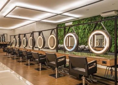 Interior elegante do salão NailStudioStefany em Aveiro, Aveiro, PT, com espelhos iluminados e cadeiras modernas.