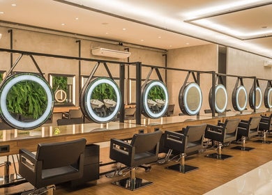Interior moderno do NailStudioStefany em Aveiro, Aveiro, PT, com cadeiras de salão e espelhos iluminados.