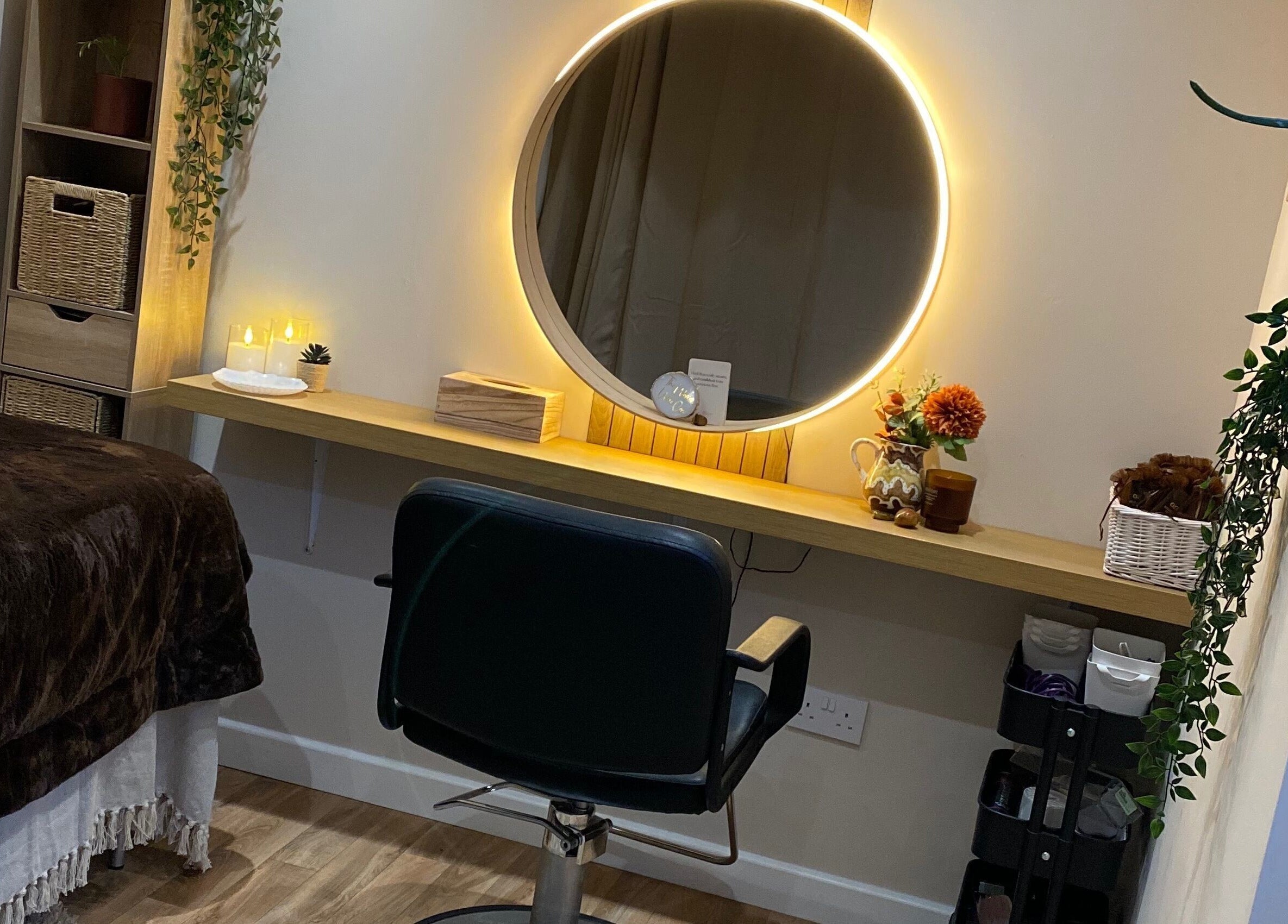 Cozy treatment room at The Healing Head Spa, Leighton Buzzard, England, GB, featuring a lit mirror and chair.