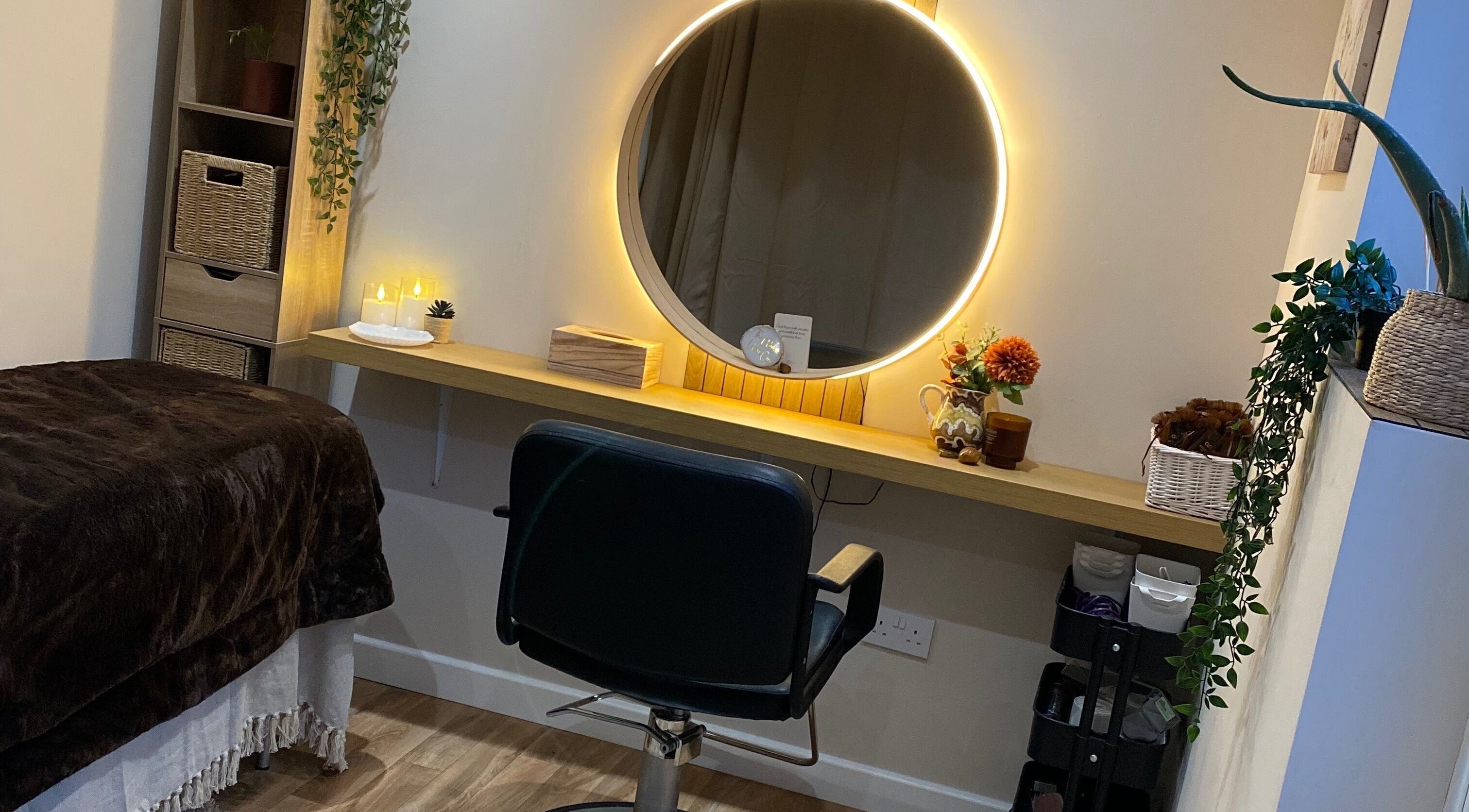 Cozy treatment room at The Healing Head Spa, Leighton Buzzard, England, GB, featuring a lit mirror and chair.