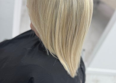 Sleek blonde hair finish at Glamourhair, London, England, GB, showcasing expert styling and shine.