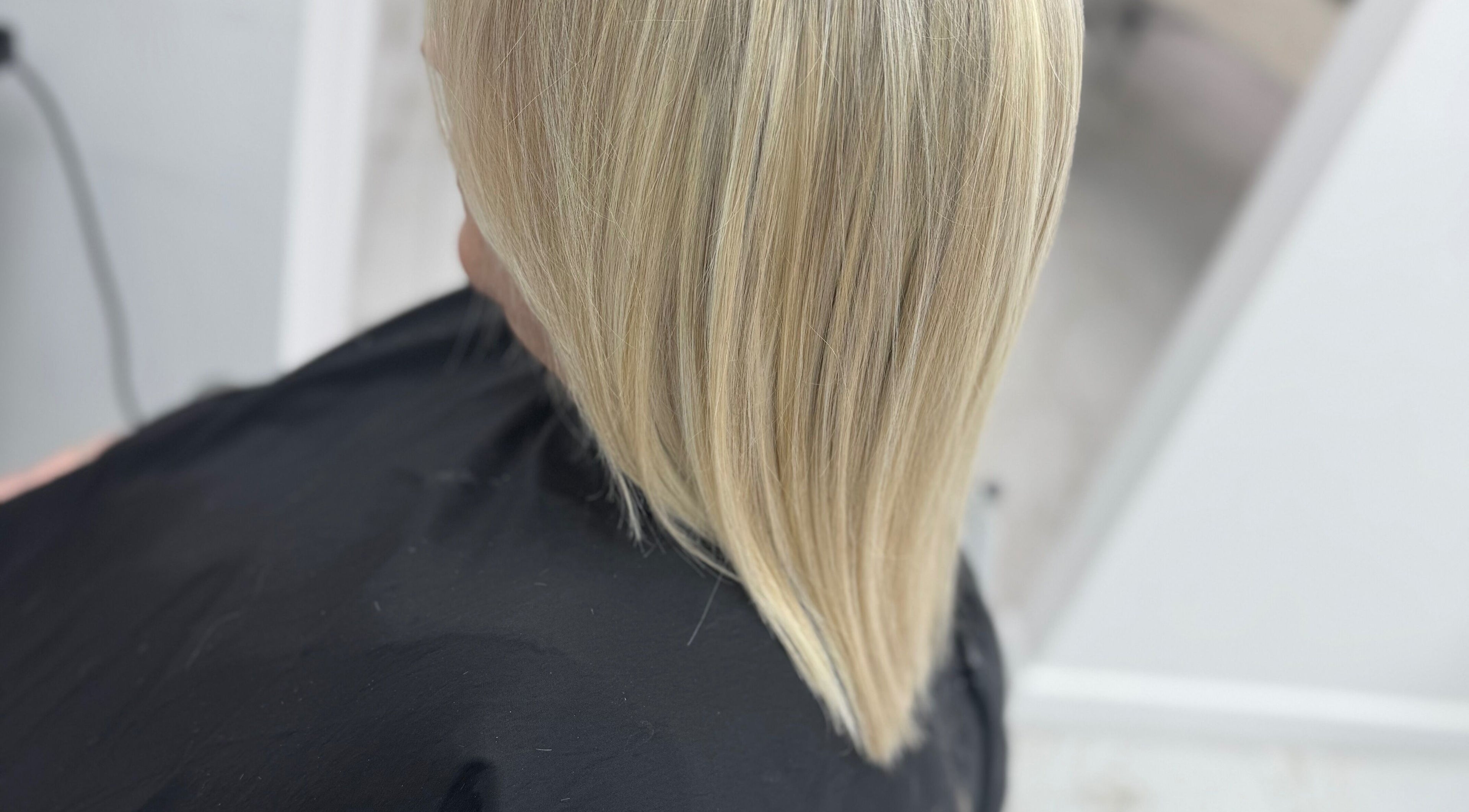 Sleek blonde hair finish at Glamourhair, London, England, GB, showcasing expert styling and shine.