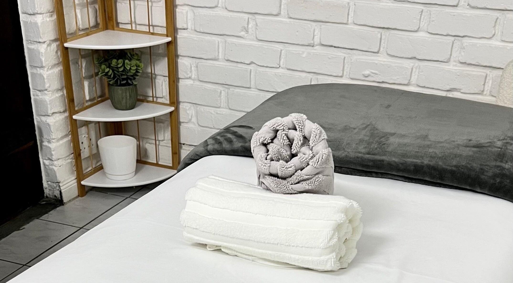 Relaxing spa bed with folded towels at B A R E, Johannesburg, Gauteng, ZA. Experience tranquility and comfort.