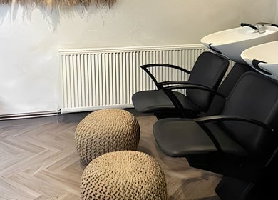 Elegant hair washing area at Amica Hair & Beauty Thirsk, Thirsk, England, GB with modern black chairs.