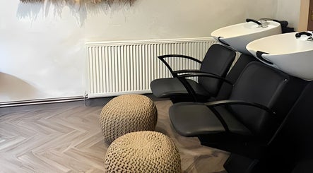 Elegant hair washing area at Amica Hair & Beauty Thirsk, Thirsk, England, GB with modern black chairs.