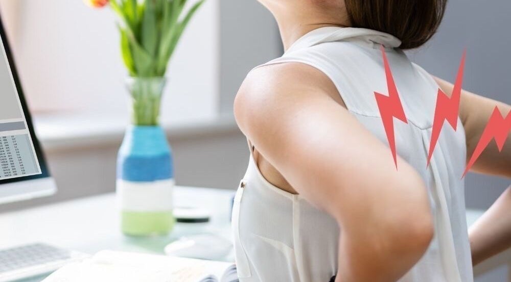 Woman experiencing back pain at Chiro Magic, NYC, New York, US. Chiropractic solutions for body aches.