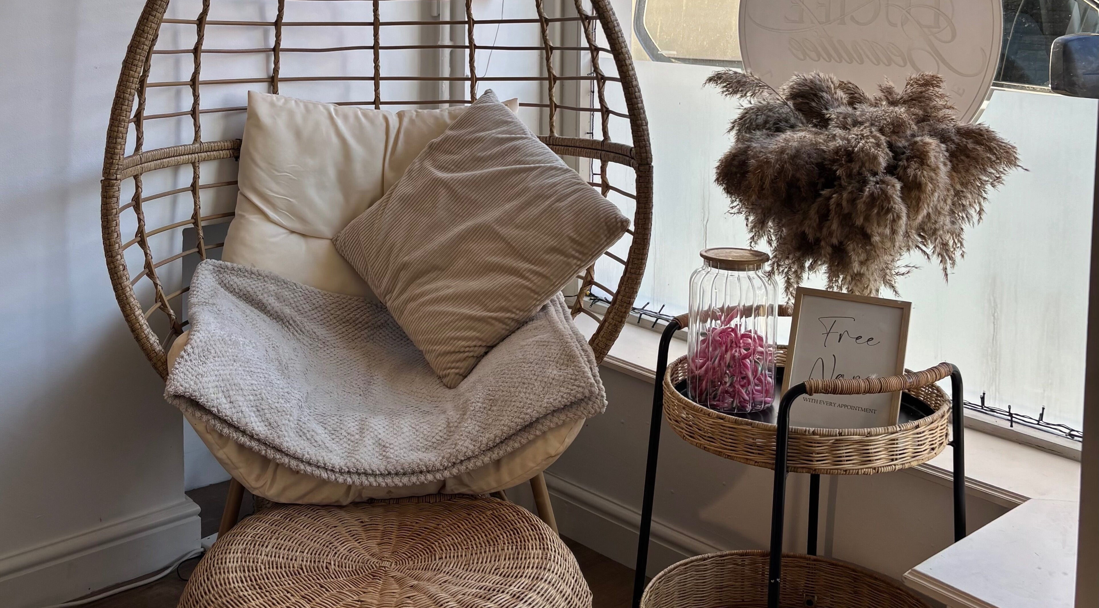 Relaxing wicker chair nook at KB Beauty Room, Senghenydd, Wales, GB, offering a tranquil spa ambience.