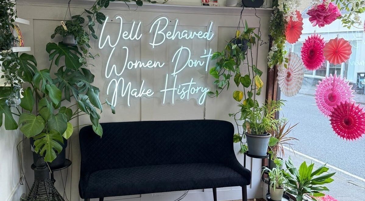 Cozy corner at Bare and Beautiful with Zoe, Faringdon, England, GB with plants and neon sign.