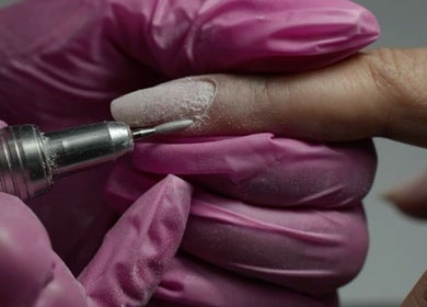 Manicura profesional en Albaruizbelleza, Socuéllamos, Castilla-la Mancha, ES, con guantes rosas.
