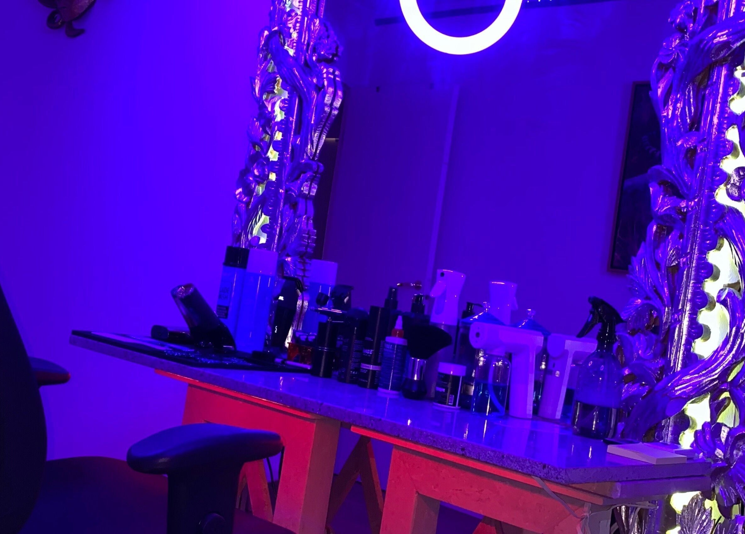 Modernt spegelbord med produkter hos JeyBlendz, Älvsjö, Stockholms Län, SE, upplyst i lila.