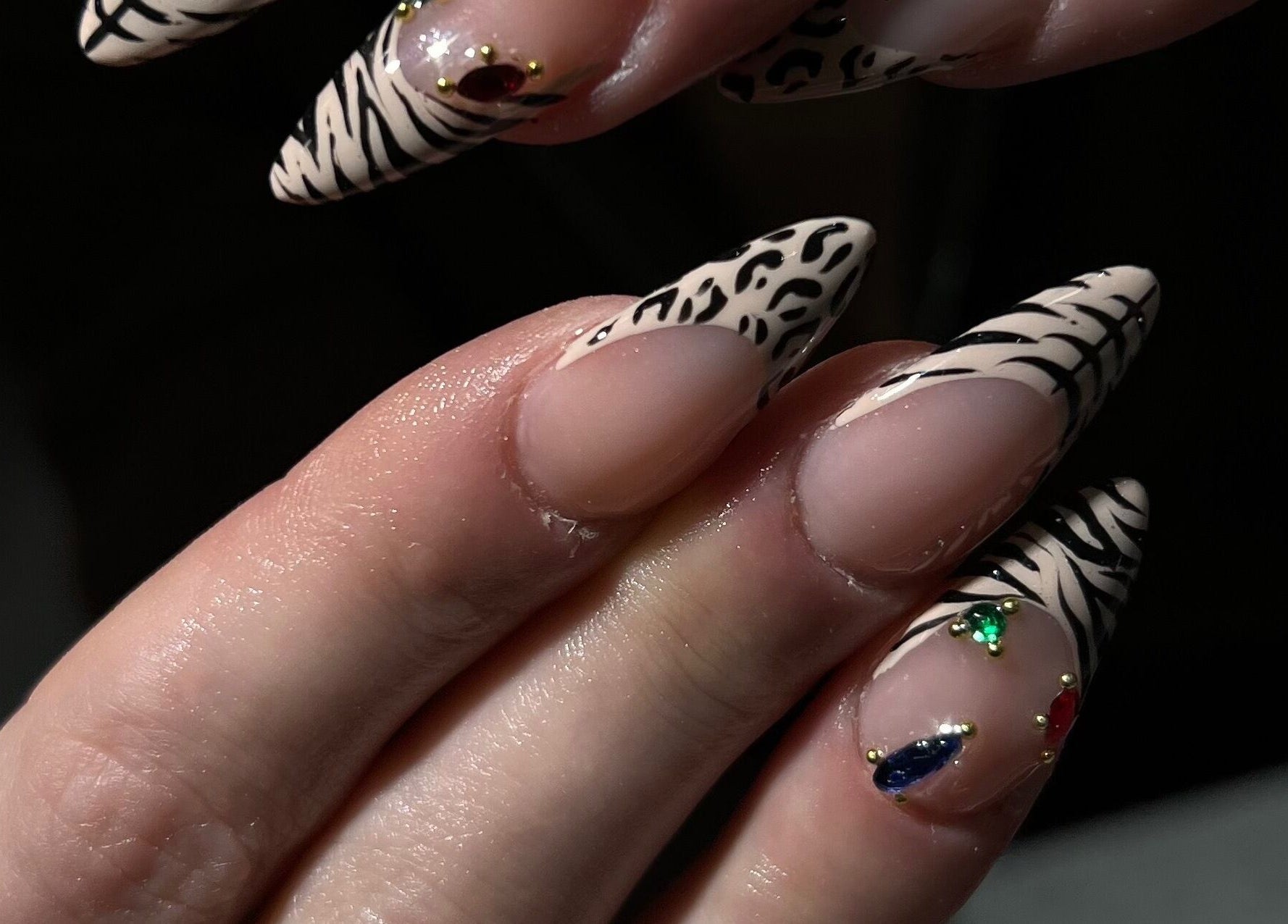 Close-up of zebra-patterned nails with gems at ChristianShS, Stockport, England, GB.