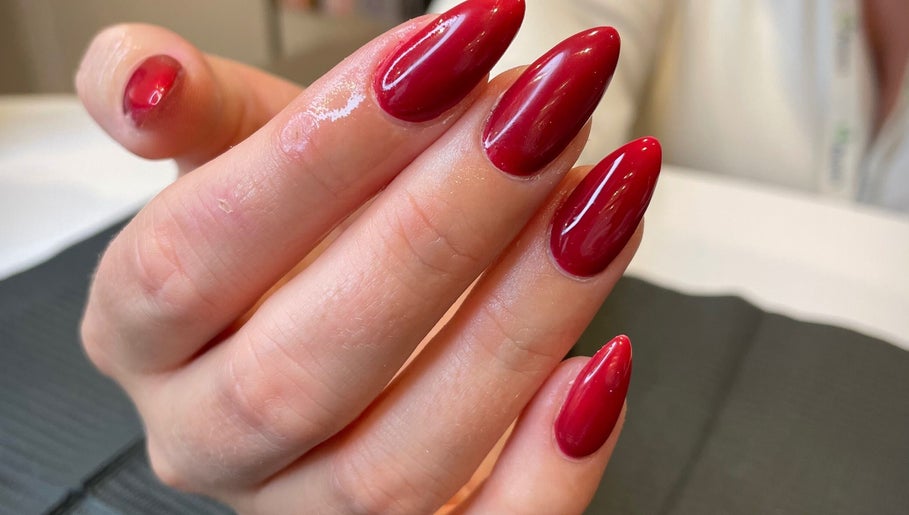 Elegant crimson nail art at Dolluxe Beauty, Aberdeen, Scotland, GB showcasing sophisticated manicure style.