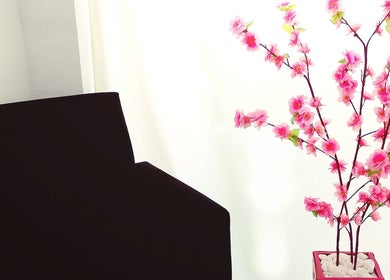 Detalhe da decoração no Maiza Beauty - São Caetano do Sul, SP, com flores e cadeira preta.