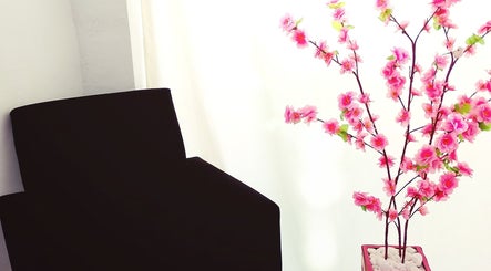 Detalhe da decoração no Maiza Beauty - São Caetano do Sul, SP, com flores e cadeira preta.