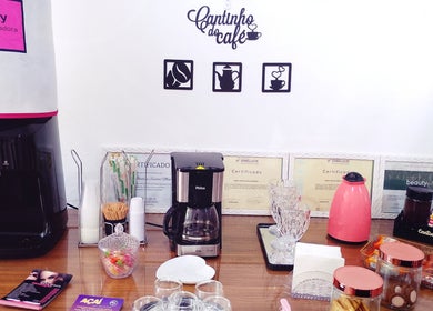 Cantinho do café em Maiza Beauty - São Caetano do Sul, com cafeteiras e certificados expostos.