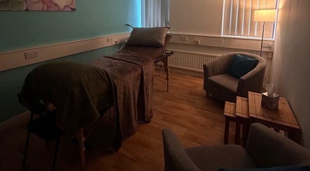 Relaxing therapy room at Thyme to Unwind Therapies, Gloucester, England, GB with soft lighting and comfy seating.